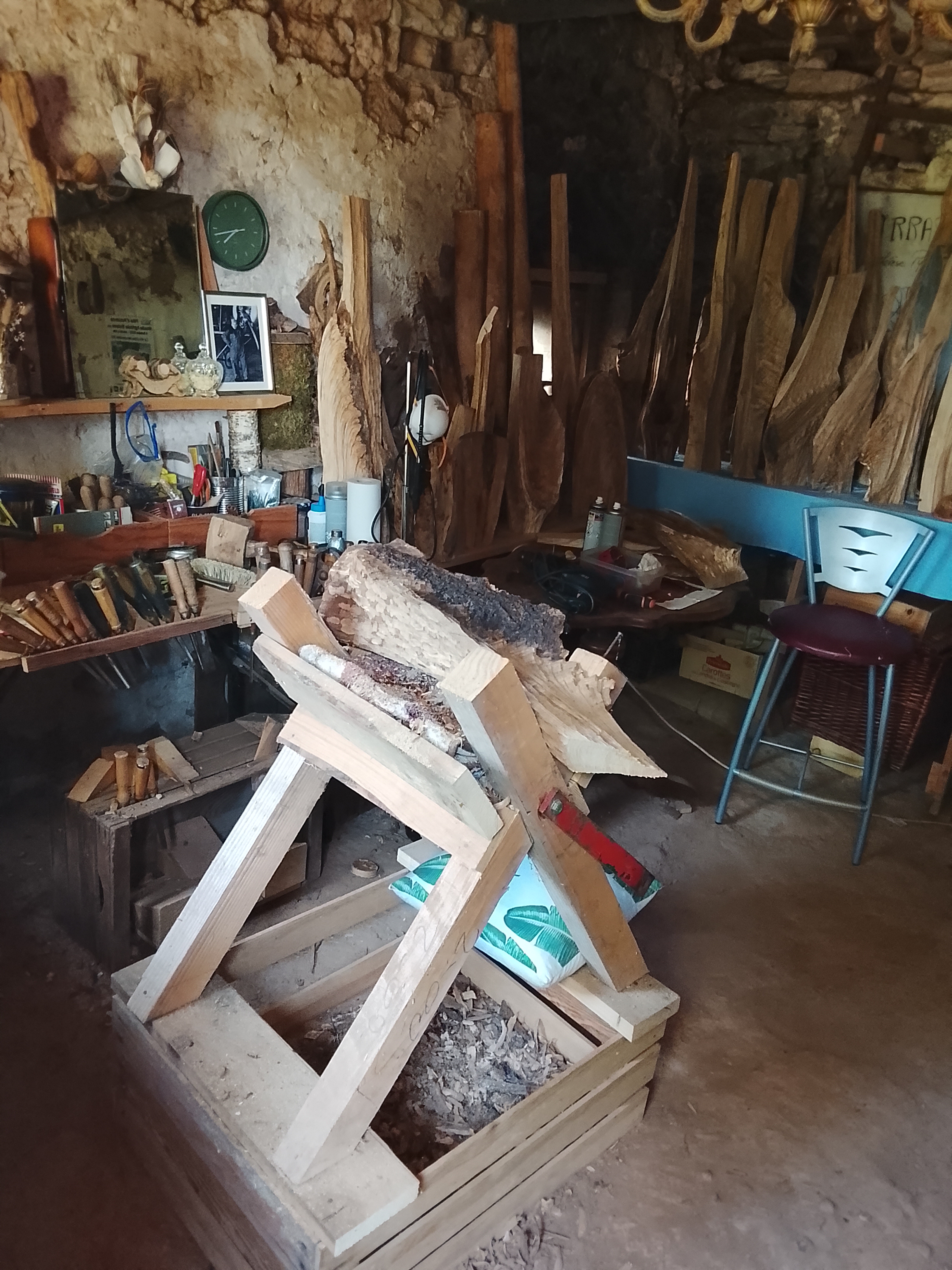 L'Atelier de Marie-Thérèse Lecrille — cave de pierre, outils sur l'établi, planches de chêne en attente
